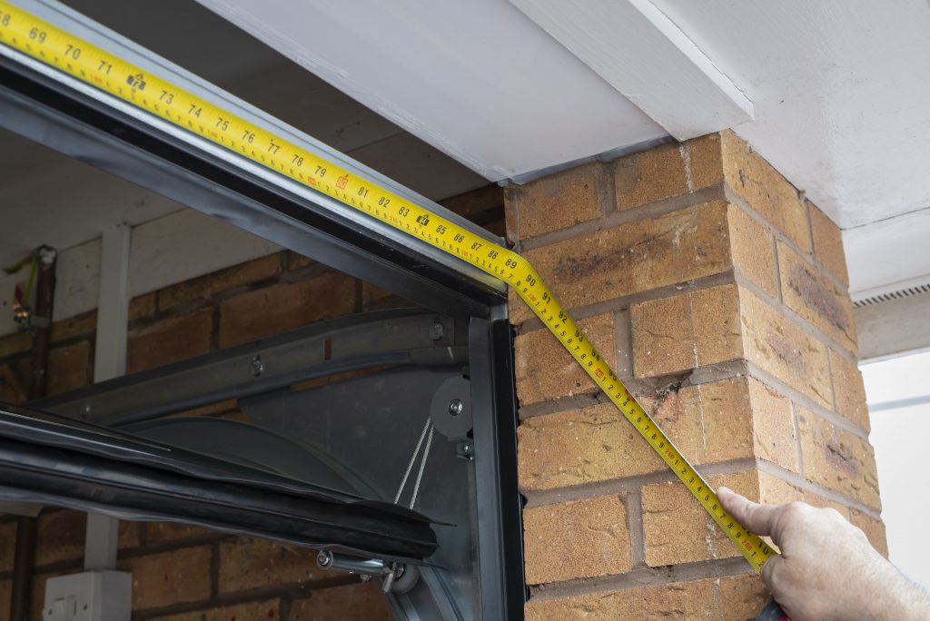 A Roché Engineer Measuring For A Roller Shutter